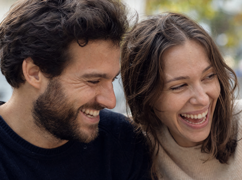 A couple laughing together outside in daylight